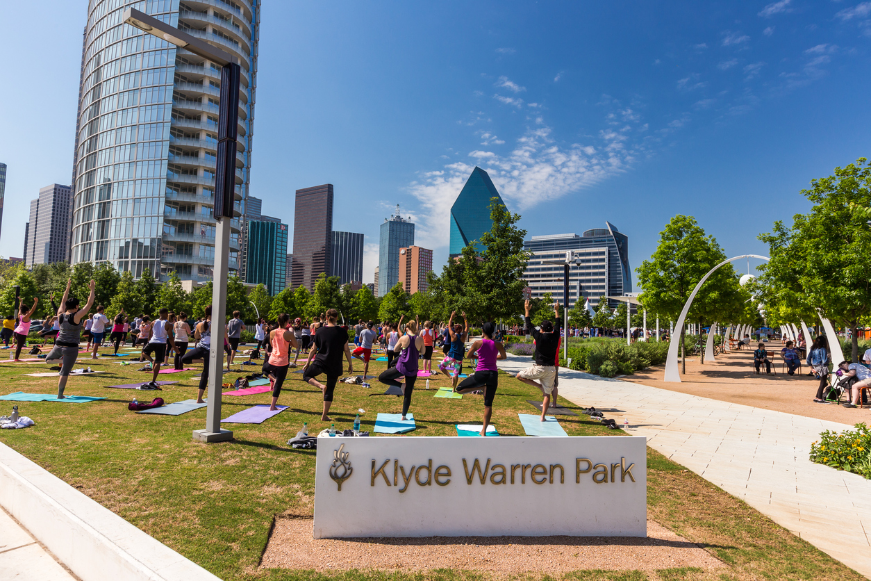 Group of people are doing yoga in Klyde Warren Park in downtown Dallas